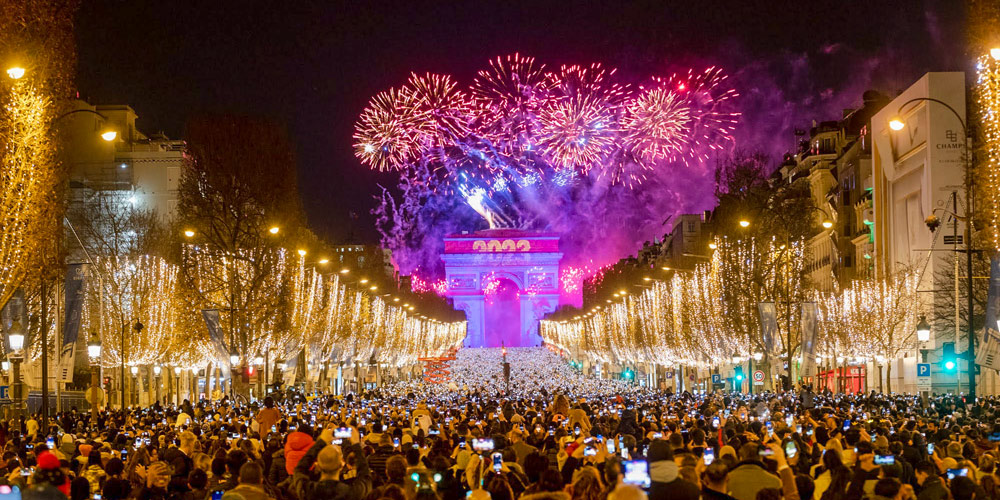 A massive crowd on Champs-Élysées view the fireworks on the Arc de Triomphe on New Years in Paris