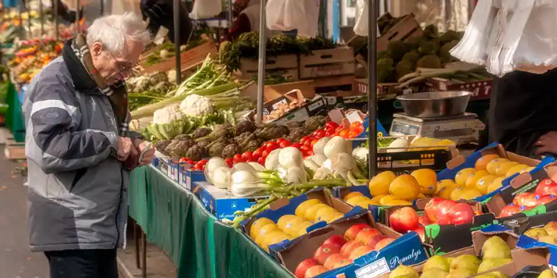 Customer shopping a produce stall at the Aligre Street Market