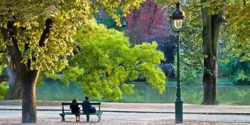 Couple sitting beside the lake in Parc des Buttes-Chaumont