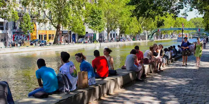 People sitting along Canal Saint-Martin in the 10th Arrondissement, Paris