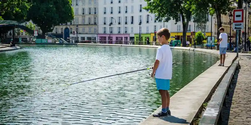 Child fishing along Canal Saint-Martin in Paris's 10th Arrondissement