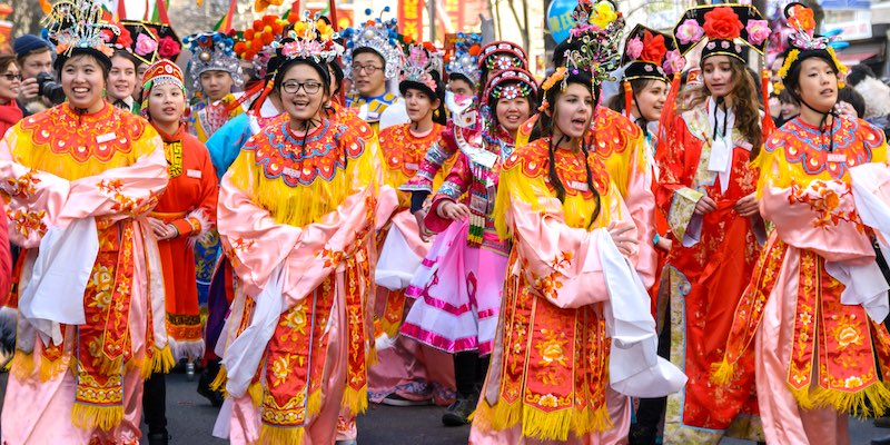 Women wear colorful traditional costumes at a Chinese New Year parade in Paris