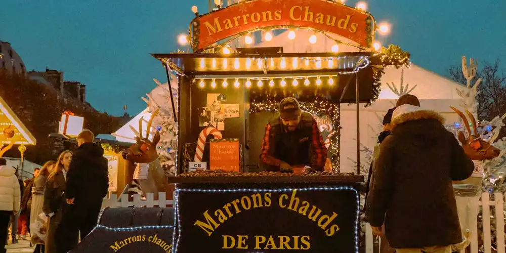 At a Paris Christmas market a booth selling roasted chestnuts