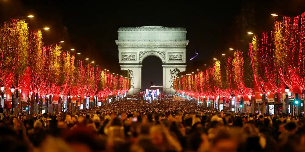 Photo by France24 Night view of the red-themed Christmas lights along the Champs-ELysees in Paris with the Arc de Triomphe in the background