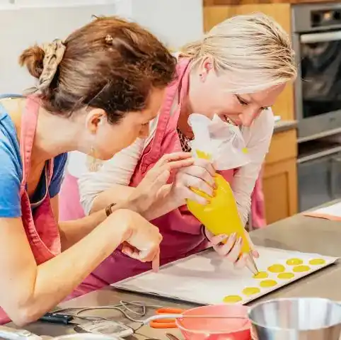 Participants piping macarons during a hands-on cooking class in Paris