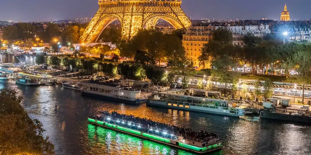 A dinner cruise bateaux cruises beneath the Eiffel Tower