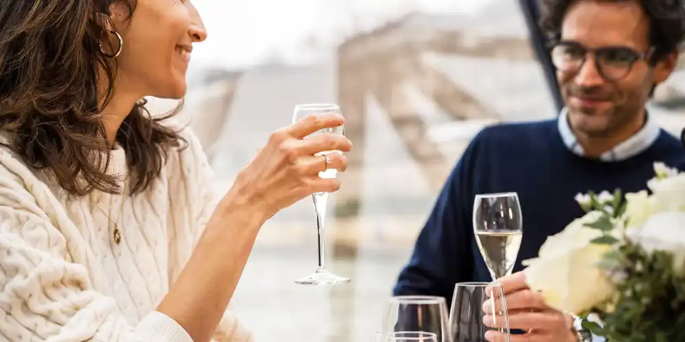 A smiling couple with wine on Valentines Day during a Romantic Dinner Cruise on the Seine