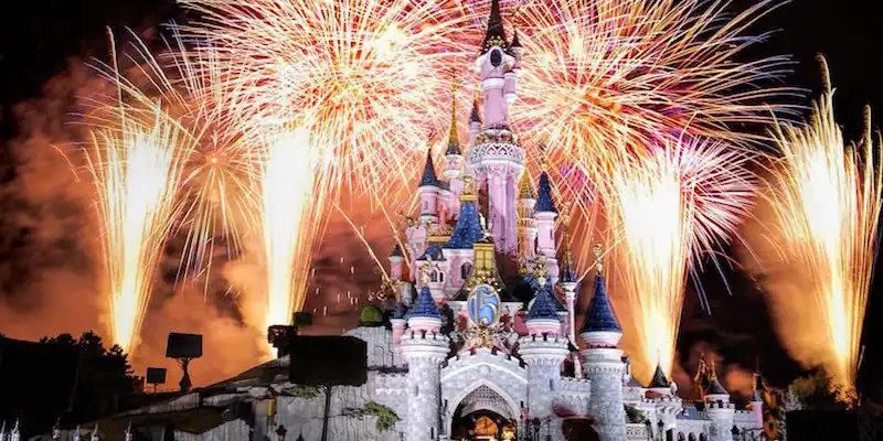The Disneland castle lit up by fireworks