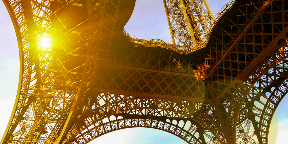 A light flare, looking up at the base of the Eiffel Tower