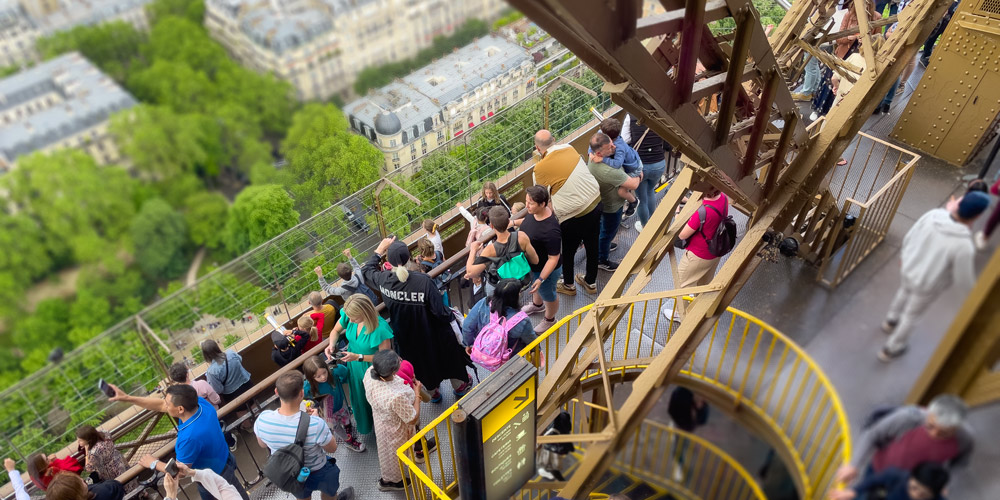 A tour group looks down on the 7th Arrondissement from Level 2 of the Eiffel Tower, photo by Mark Craft