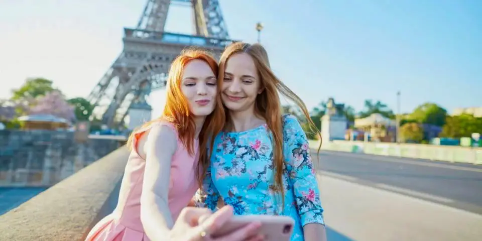 Two women taking a selfie in fromof the Eiffel Tower