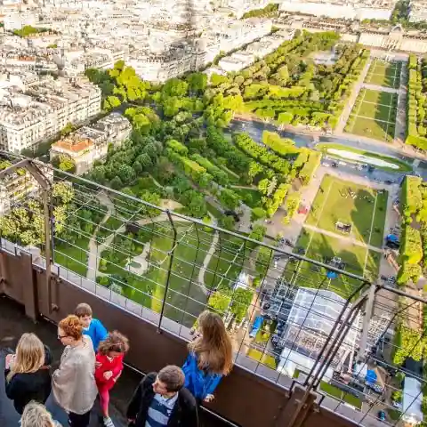 View over Paris from the Eiffel Tower with visitors at the railing