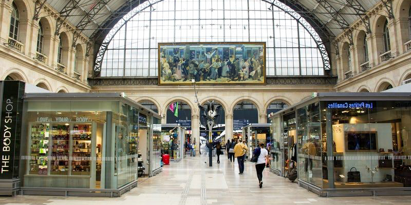 The interior of Gare de l'Est with its arched window and mural Le Départ des Poilus