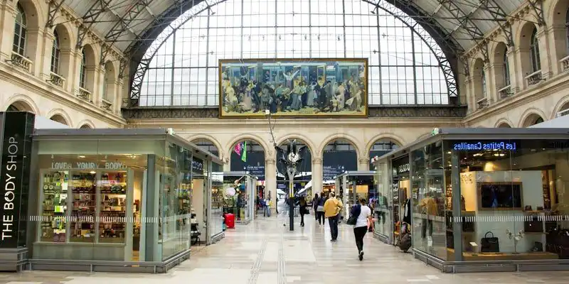 The interior of Gare de l'Est with its arched window and mural Le Départ des Poilus