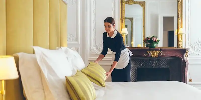 A maid completes final touches in a classic room at Alfred Sommier