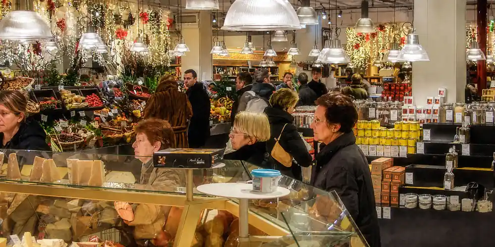 Shoppers at the cheese and produce counters inside La Grande Epicerie de Paris at Christmas.