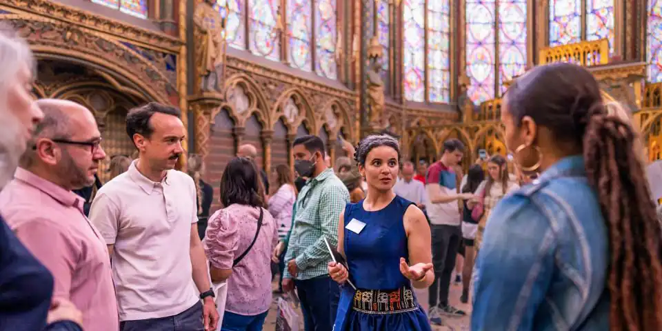 An expert guide shows off the magnficient stained glass windos of La Sainte Chapelle