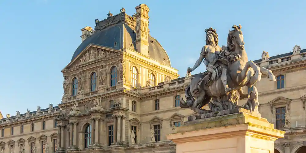 Louvre Museum facade and Louis XIV equestrian statue in the Cour Napoléon, Paris