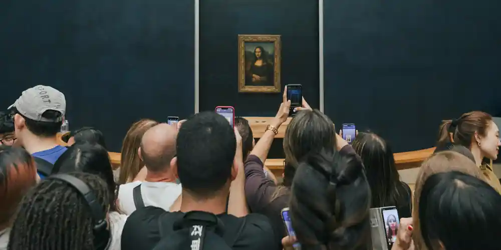 At the Louvre a crowd in front of the Mona Lisa, taking photos