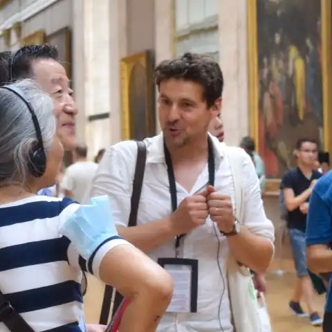 Guide speaking to a small group inside the Louvre museum in Paris