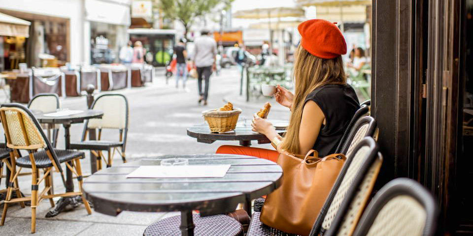 A woman in a red beret at a sidewalk cafe in Montmartre