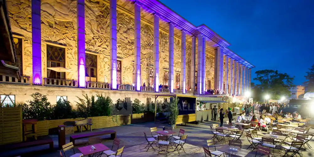 Facade of Palais de la Porte Dorée during an evening event