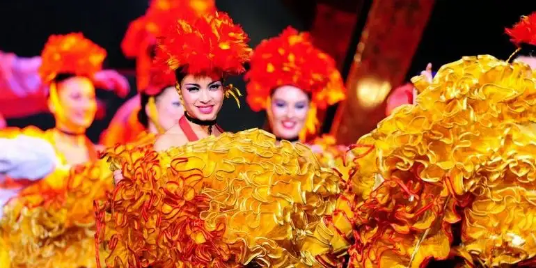 Dancers with pom-poms and red feather headdresses at Paradis Latin