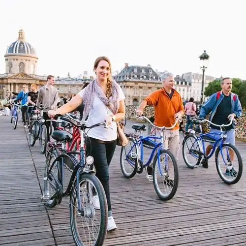 People on a bike tour crossing Pont des Arts in central Paris