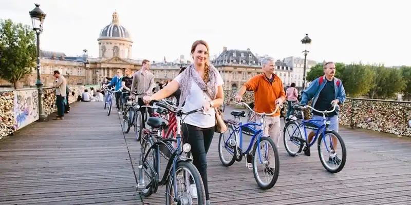 Guided Paris bicycle tour riding across Pont des Arts