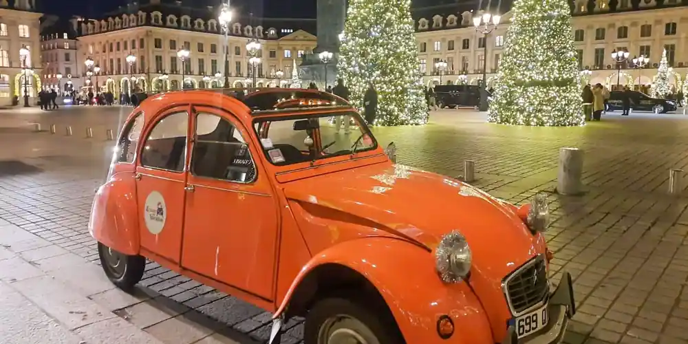 Classic Citroën 2CV beside Christmas trees in Place Vendôme, Paris