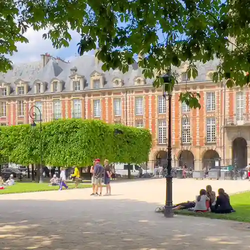 Place des Vosges square with people relaxing in the Marais district of Paris
