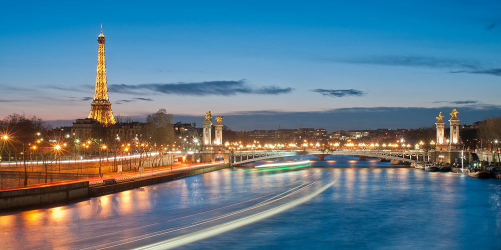 Pont Alexandre III with the Eiffel Tower and the Seine river in the early evening blue sky
