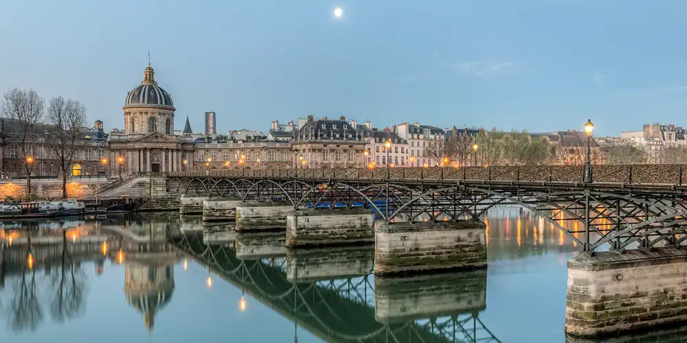 Pont des Arts, the dome of the Institut de France reflected in the Seine, photo Wikimedia by Daniel Vorndran