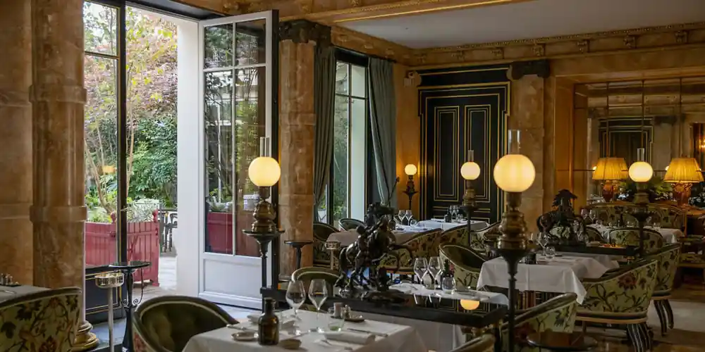 Dining room at Le Gabriel opening onto the garden at La Réserve Paris