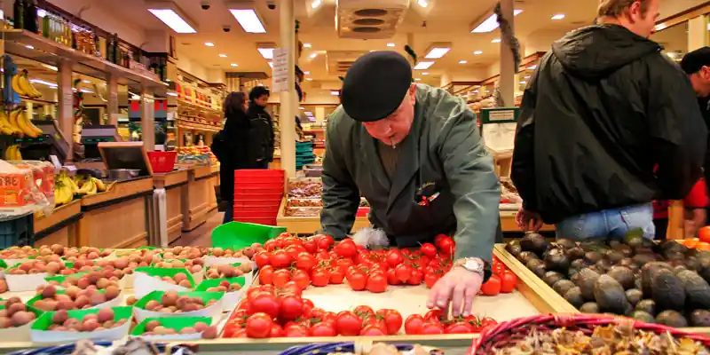 A produce vendor arranges tomatoes on Rue Cler in 2006