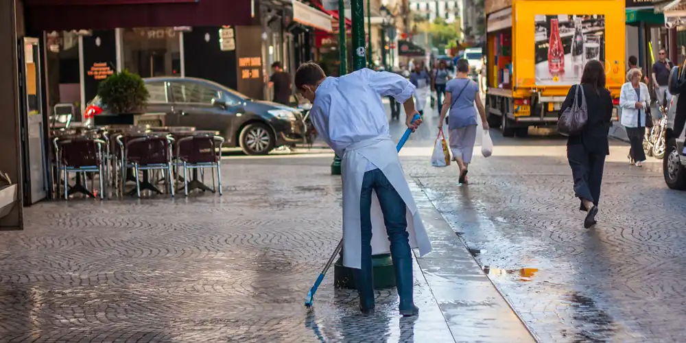 Cleaning the sidewalks at Poissonnerie Soguisa, photo Mark Craft 2010