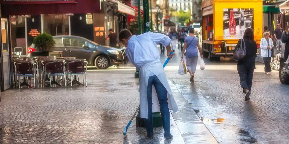 Worker washing Rue Montorgueil in Paris