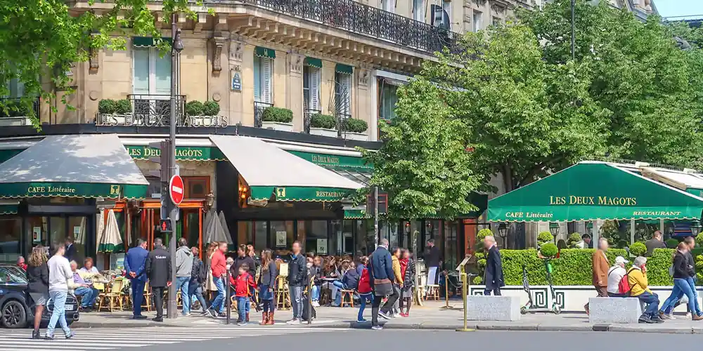 Café terrace at Les Deux Magots in Saint-Germain-des-Prés, Paris, with people dining outdoors