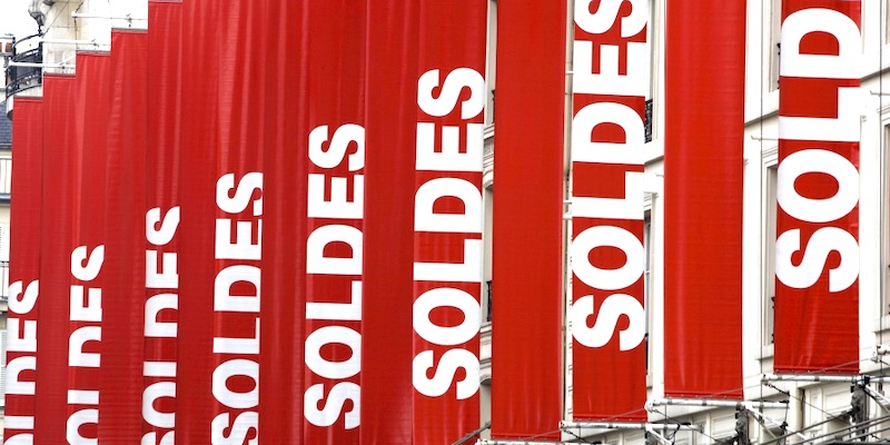 Red banners announcing the annual sales at a Paris department store