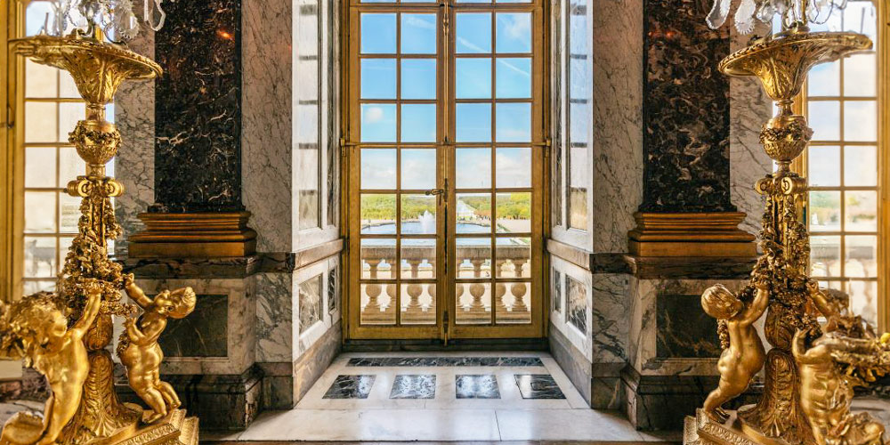 Looking through a window at the Chateau de Versailles at the gardens and ponds outside