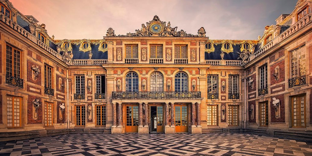 The main entrance to the Chateau de Versailles at sunset