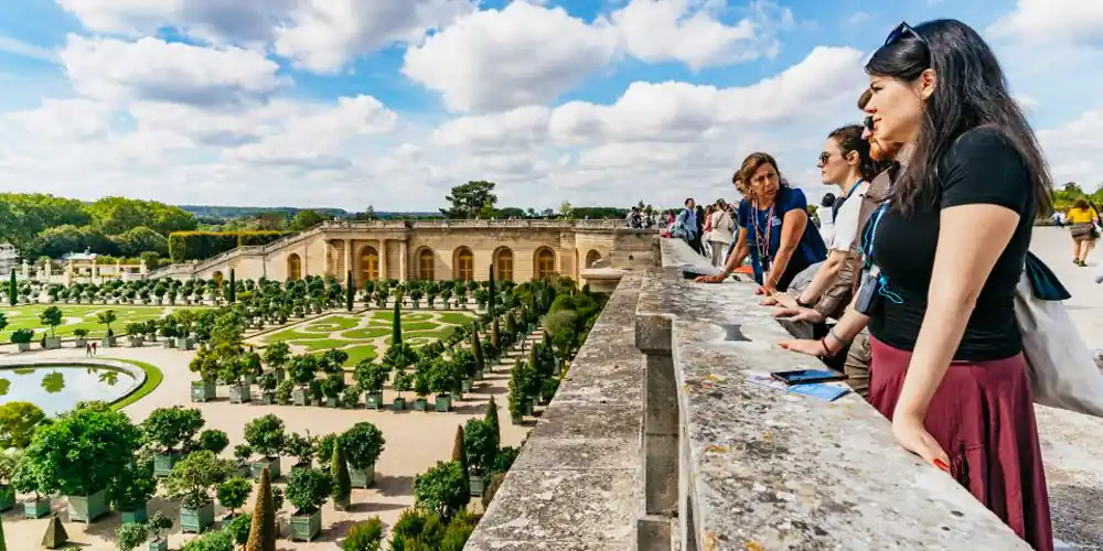 Guide with a small tour group overlooking the gardens of Versailles